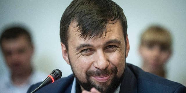 FILE - In this Wednesday May 14, 2014 file photo Denis Pushilin, leader of the insurgency that has declared an independent "people's republik" in the Donetsk region, speaks at a news conference in eastern Ukraine city of Donetsk. The Donetsk People’s Republic is starting to smell. Rotting garbage is piling up in the hallways of the government office building seized by separatists in eastern Ukraine. Telephones ripped from the walls are piled atop broken furniture and mounds of old files. The stench of sweat and stale cigarettes is everywhere. The guards, slouching men with pistols shoved in their pockets or flapping loosely in holsters, look increasingly bored. (AP Photo/Evgeniy Maloletka, File)