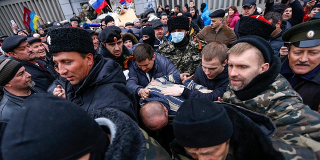April 13, 2014: Pro-Russian protesters escort a man detained in eastern Ukraine.