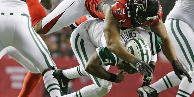 FILE - In this Oct. 7, 2013, file photo, New York Jets quarterback Geno Smith (7) is sacked by Atlanta Falcons defensive end Osi Umenyiora (50) during the second half of an NFL football game in Atlanta. Umenyiora still plays video games online with former Giants teammate Victor Cruz. On Sunday, Oct. 5, 2014, they'll go against each other for real for the first time. (AP Photo/David Goldman, File)