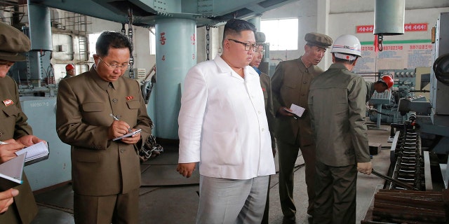 North Korean leader Kim Jong Un, center, speaks during a visit to a machine factory in North Hamgyong Province, North Korea.