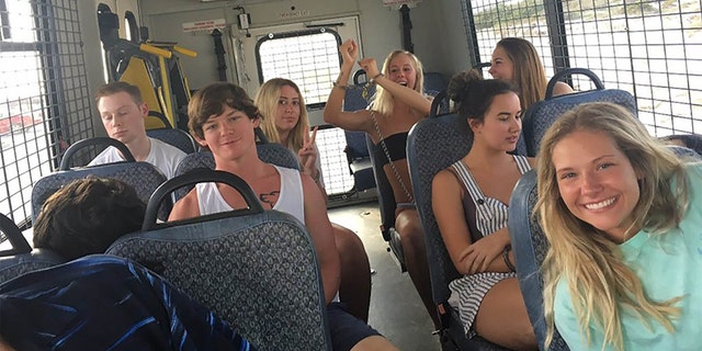 A bus full of 14 underage drinkers posed for the camera on their way to jail.