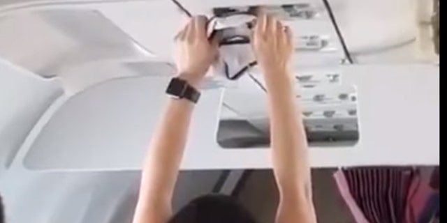 A woman on a flight from Turfy to Russia was caught on video drying a pair of underwear with the overhead vent.