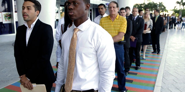 FILE - In this Wednesday, Oct. 23, 2013, file photo, Luis Mendez, 23, left, and Maurice Mike, 23, wait in line at a job fair held by the Miami Marlins, at Marlins Park in Miami. Employers added a scant 74,000 jobs in December after averaging 214,000 in the previous four months. The Labor Department said Friday, Jan. 10, 2014, that the unemployment rate fell from 7 percent in November to 6.7 percent, its lowest level since October 2008. But the drop occurred mostly because many Americans stopped looking for jobs. Once people without jobs stop looking for one, the government no longer counts them as unemployed. (AP Photo/Lynne Sladky, File)