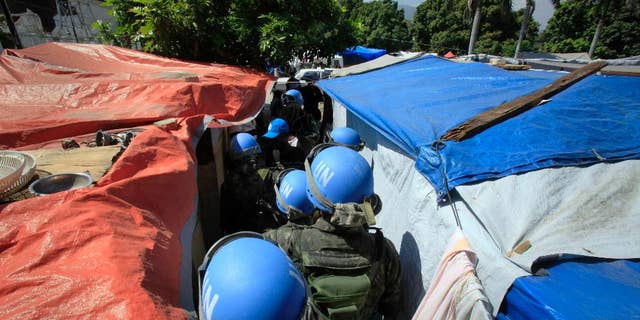 FILE - In this Tuesday, March 30, 2010 file photo, United Nations peacekeepers patrol an earthquake survivors makeshift camp in Port-au-Prince. In 2015, troubled by peacekeepers' sexual relationships with the people they are meant to protect, the UN has quietly started helping with DNA collection to prove paternity claims for so-called "peacekeeper babies." (AP Photo/Jorge Saenz)
