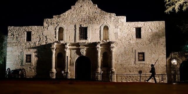 FILE - In this March 6, 2013, file photo, John Potter, a member of the San Antonio Living History Association, patrols the Alamo in San Antonio, during a pre-dawn memorial ceremony to remember the 1836 Battle of the Alamo and those who fell on both sides. The San Antonio Missions in Texas have been awarded world heritage status by the U.N.'s cultural body.UNESCO's World Heritage Committee approved the listing Sunday, July 5, 2015, of the five Spanish Roman Catholic sites built in the 18th century in and around what is now the city of San Antonio. (AP Photo/Eric Gay, File)