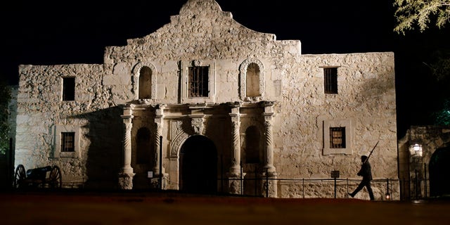FILE - In this March 6, 2013, file photo, John Potter, a member of the San Antonio Living History Association, patrols the Alamo in San Antonio, during a pre-dawn memorial ceremony to remember the 1836 Battle of the Alamo and those who fell on both sides. The San Antonio Missions in Texas have been awarded world heritage status by the U.N.'s cultural body.UNESCO's World Heritage Committee approved the listing Sunday, July 5, 2015, of the five Spanish Roman Catholic sites built in the 18th century in and around what is now the city of San Antonio. (AP Photo/Eric Gay, File)