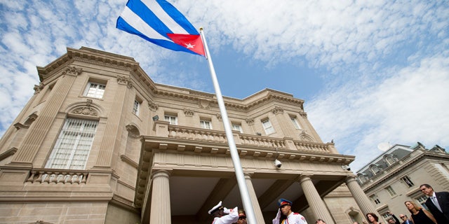 FILE- In this July 20, 2015, file photo, Cuban Foreign Minister Bruno Rodriguez, right of center, applauds with other dignitaries after raising the Cuban flag over their new embassy in Washington. (AP Photo/Andrew Harnik, Pool, File)