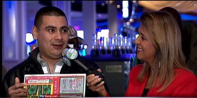 December 27, 2013: Marvin Martinez, left, speaks to a New York Lottery official after being announced as the official holder of a $1M ticket he found after Superstorm Sandy (MyFoxNY.com)