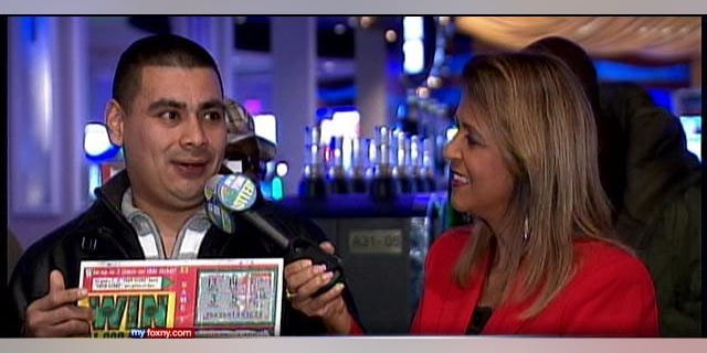 December 27, 2013: Marvin Martinez, left, speaks to a New York Lottery official after being announced as the official holder of a $1M ticket he found after Superstorm Sandy (MyFoxNY.com)