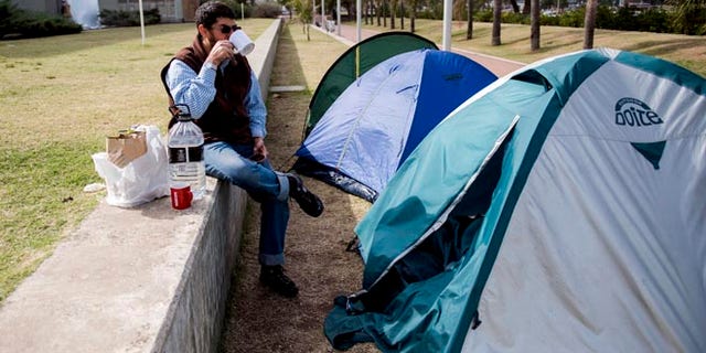FILE - In this May 6, 2015 file photo, Omar Abdelhadi Faraj drinks tea in front of his tent outside the U.S. embassy as a form of protest in Montevideo, Uruguay. Faraj's attorney Mauricio Pigola said Sunday, Jan. 24, 2016 that his client was released after a judge found insufficient evidence against him in a domestic violence case. Faraj is a Syrian who arrived to Uruguay in December 2014 with five other ex-prisoners once held with terror suspects at the U.S. military base in Guantanamo, Cuba. (AP Photo/Matilde Campodonico, File)