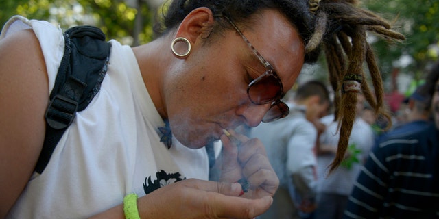 A man smokes a marijuana cigarette during a demonstration in support of the legalization of marijuana outside the Congress in Montevideo, Uruguay, Tuesday, Dec. 10, 2013. Uruguay's Senate was finishing its final debate Tuesday before voting on a plan to create the world's first national marijuana market, with the state regulating the entire process of growing, selling and using a drug that is illegal almost everywhere else. (AP Photo/Matilde Campodonico)
