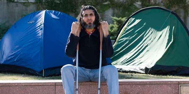 In this May 5, 2015 photo, former Guantanamo detainee Abu Wa'el Dhiab from Syria sits in front of the U.S. embassy while visiting former fellow detainees who were demanding financial assistance from the U.S., in Montevideo, Uruguay. Dhiab, who resettled in Uruguay, was briefly hospitalized Monday, Sept. 5, 2016, after becoming weak from a hunger strike. Dhiab is demanding that he be allowed to leave the South American country. Uruguay took in Dhiab and five other former Guantanamo prisoners for resettlement in 2014. (AP Photo/Matilde Campodonico)