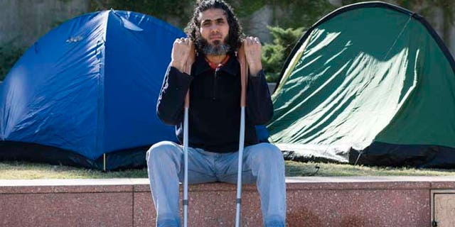 In this May 5, 2015 photo, former Guantanamo detainee Abu Wa'el Dhiab from Syria sits in front of the U.S. embassy while visiting former fellow detainees who were demanding financial assistance from the U.S., in Montevideo, Uruguay. Dhiab, who resettled in Uruguay, was briefly hospitalized Monday, Sept. 5, 2016, after becoming weak from a hunger strike. Dhiab is demanding that he be allowed to leave the South American country. Uruguay took in Dhiab and five other former Guantanamo prisoners for resettlement in 2014. (AP Photo/Matilde Campodonico)