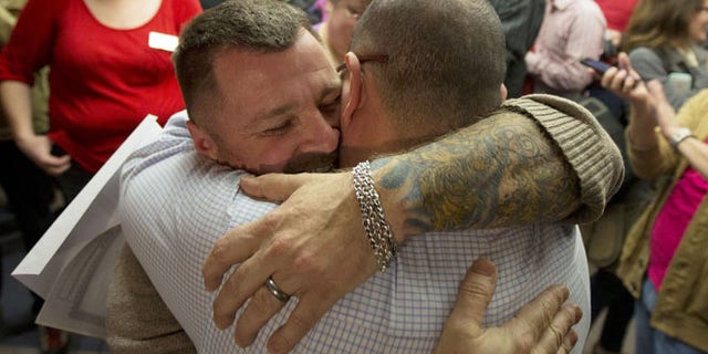 Dec. 20, 2013 file photo, Chris Serrano, left, and Clifton Webb embrace after being married, at the marriage division of the Salt Lake County Clerk's Office in Salt Lake City.