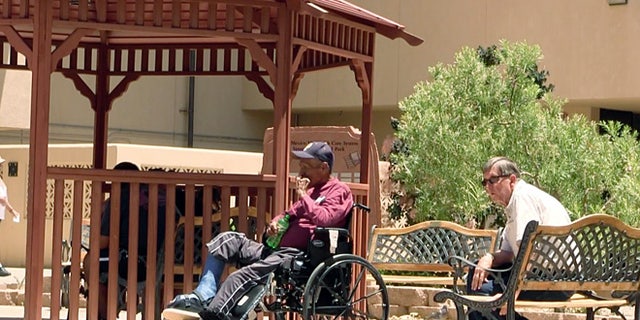 Men sit outside the Raymond G. Murphy VA Medical Center in Albuquerque, New Mexico, in July 2014. 