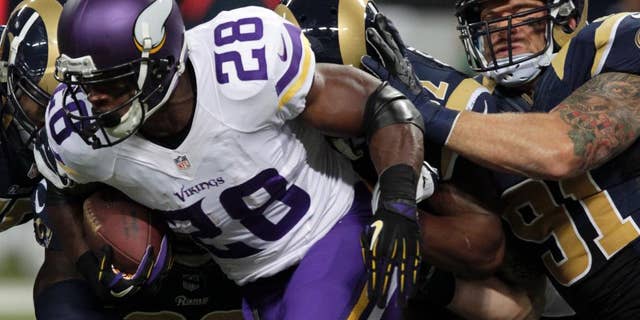 Adrian Peterson, de los Vikings de Minnesota, acarrea el balón frente a los Rams de San Luis, el domingo 7 de septiembre de 2014 (AP Foto/Tom Gannam)