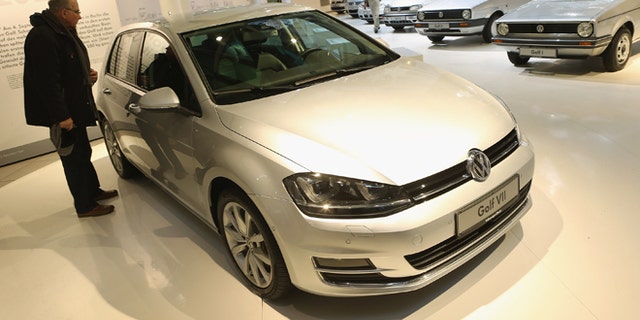 BERLIN, GERMANY - JANUARY 14: A visitor looks at a VW Golf VII as the six previous generations of Volkswagen cars stand lined up behind at a Volkswagen Group showroom on January 14, 2013 in Berlin, Germany. Volkswagen Group, which includes the VW, Audi, Porsche, Skoda, SEAT, Bentley and Bugatti brands, delivered a record 9.07 million cars to customers in 2012. Rising sales in the Americas and Asia helped to offset a drop in sales in western Europe. (Photo by Sean Gallup/Getty Images)
