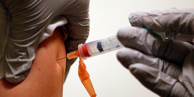 Six-year-old Diego Sanson receives an influenza vaccine injection at Massachusetts General Hospital in Boston, Massachusetts January 10, 2013. With flu cases in this city up tenfold from last year, the mayor of Boston declared a public health emergency January 9 as authorities around the United States scrambled to cope with a rising number of patients. REUTERS/Brian Snyder (UNITED STATES - Tags: HEALTH SOCIETY) - RTR3CANZ
