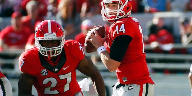 Georgia quarterback Hutson Mason (14) looks for a receiver as Georgia running back Nick Chubb (27) runs a pass route in the first half of an NCAA college football game against Vanderbilt Saturday, Oct. 4, 2014, in Athens, Ga. Georgia won 44-17. (AP Photo/John Bazemore)