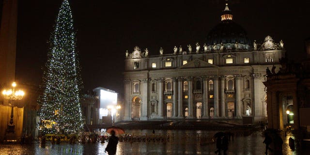 Dec. 17: People walk past the Christmas tree in St. Peter's square, at the Vatican, that was lit for the first time Dec. 17.