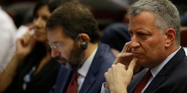 New York Mayor Bill de Blasio, right, flanked by Rome Mayor Ignazio Marino, center, and Paris Mayor Anne Hidalgo attend a conference on Modern Slavery and Climate Change in the Synod Hall at the Vatican, Tuesday, July 21, 2015. Dozens of environmentally friendly mayors from around the world are meeting at the Vatican this week to bask in the star power of eco-Pope Francis and commit to reducing global warming and helping the urban poor deal with its effects. (AP Photo/Gregorio Borgia)