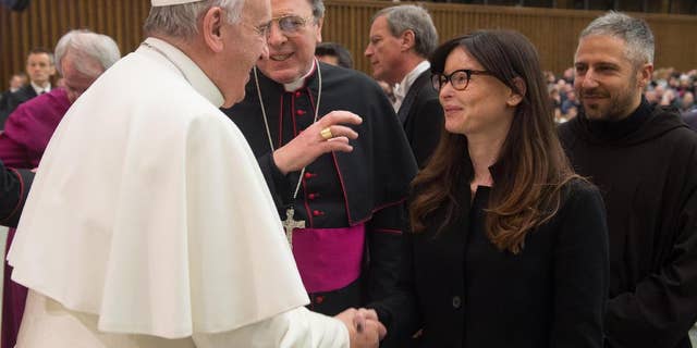 FILE -- In this file photo taken at the Vatican, on Feb. 4, 2015, Pope Francis shakes hands with Italian lawyer Lucia Annibali during the weekly general audience in the Pope Paul VI hall, . Annibali, became a symbol in the fight against men's violence toward women, after suffering in the 2013 an acid attack masterminded by her ex-boyfriend Luca Varani, also a lawyer. Varani has been convicted and sentenced to 20 years in prison for ordering the attack on his ex-girlfriend. Two Albanian men were convicted of throwing the acid and each received a 14 year term. On saturday in a speech, Francis decried disfiguring attacks on women. (AP Photo/L'Osservatore Romano, Pool)