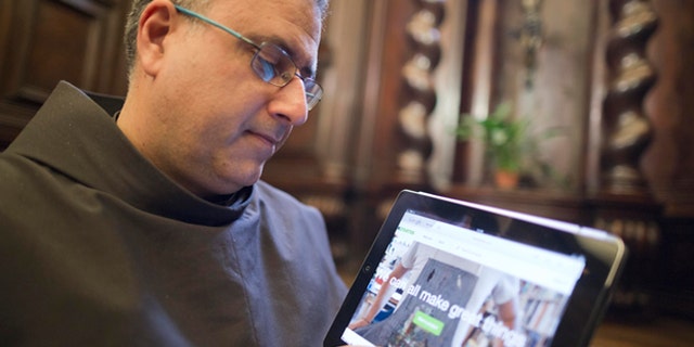 The head of the Franciscan convent of St. Francesco a Ripa, Friar Stefano Tamburo, uses a tablet device to check the Kickstart page promoting the conservation works required in the cell that St. Francis of Assisi is believed to have used when visiting the convent in Rome, Friday, Feb. 28, 2014. The friars who run the St. Francis a Ripa church in Rome's Trastevere neighborhood are launching a Kickstarter online fundraising campaign Tuesday, March 11, 2014, to try to raise the $125,000 to restore the tiny cell where St. Francis stayed when he came to Rome to see the pope, The Associated Press has learned. Rather than ask for funding from the Italian government, which owns the church and is responsible for its upkeep, the friars decided on this more democratic crowdfunding initiative thinking it more in keeping with the Franciscan tradition of seeking alms for just what they need, spreading the faith as they beg, and making sure the poor are the priority. (AP Photo/Domenico Stinellis)