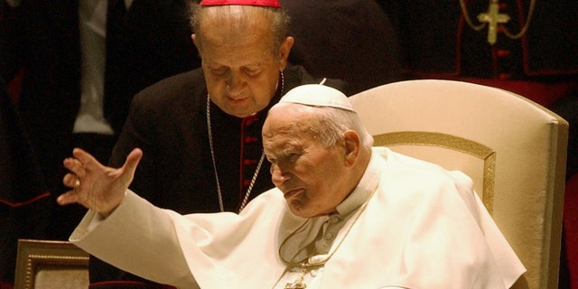 FILE - A Thursday, Oct. 16, 2003 photo from files showing Pope John Paul II with Archbishop Stanislaw Dziwisz as he arrives in the Paul VI hall to hear a "Message from the College of Cardinals to the Holy Father" at the Vatican. Pope John Paul II's secretary "did not have the courage" to burn all of the pontiff's notes after his death, and is now having some of them published, he said Wednesday, Jan. 22, 2014. The book, "Very Much in God's Hands," comes out Feb. 5 in Poland, where the pope is still a much-loved authority. It contains religious meditations that Karol Wojtyla recorded between July 1962, when he was a bishop in Poland, and March 2003, when he was pope. (AP Photo/Plinio Lepri, File)