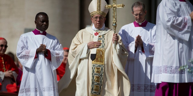 Pope Francis, center, arrives to celebrate an Easter Sunday Mass in St. Peter's Square at the Vatican Sunday, April 20, 2014. (AP Photo/Andrew Medichini)