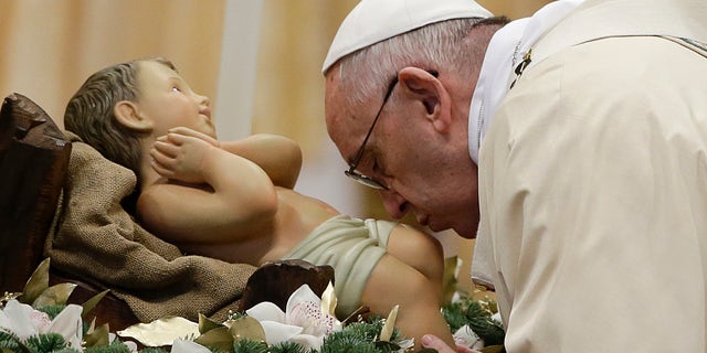 Pope Francis kisses during statue of baby Jesus a Mass in St. Peter's Basilica, at the Vatican, to mark Epiphany, Wednesday, Jan. 6, 2016. The Epiphany day is a joyous day for Catholics in which they recall the journey of the Three Kings, or Magi, to pay homage to Baby Jesus (AP Photo/Gregorio Borgia)
