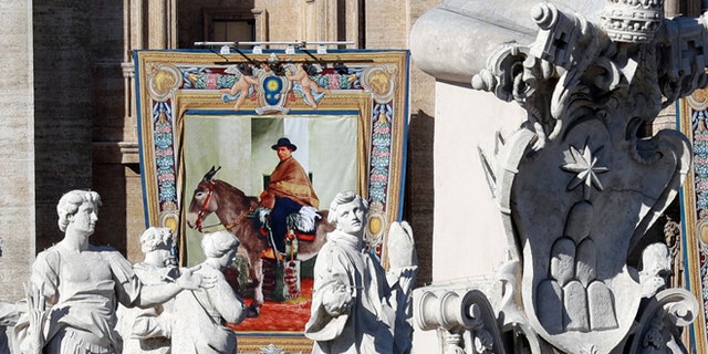The tapestry of Argentina's "gaucho priest" Jose Gabriel del Rosario Brochero hangs from the facade of St, Peter's Basilica prior to the start of a Canonization Mass celebrated by Pope Francis in St. Peter's Square, at the Vatican, Sunday, Oct. 16, 2016. The pope canonized Brochero on Sunday along with six others in one of the final big Masses of his Holy Year of Mercy. (AP Photo/Andrew Medichini)