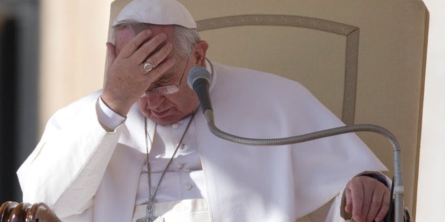 Pope Francis touches his forehead during his weekly general audience, in St. Peter's Square, at the Vatican, Wednesday, Feb. 18, 2015. (AP Photo/Andrew Medichini)