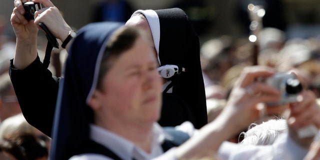 April 28, 2014: Nuns take pictures prior to the start of a thanksgiving mass celebrated by Cardinal Angelo Comastri following Sunday's canonizations of John XXIII and John Paul II, in St. Peter's Square, at the Vatican.(AP Photo/Gregorio Borgia)