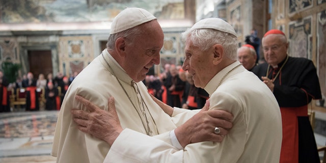 Pope Francis, left, and retired Pope Benedict XVI embrace during a ceremony to celebrate Benedict's 65th anniversary of his ordination as a priest, in the Clementine Hall of the Apostolic Palace, at the Vatican, Tuesday, June 28, 2016. The ceremony served in part to show continuity from Benedict to Francis amid continued nostalgia from some conservatives for Benedictâs tradition-minded papacy. (L'Osservatore Romano/Pool photo via AP)
