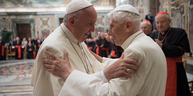 Pope Francis, left, and retired Pope Benedict XVI embrace during a ceremony to celebrate Benedict's 65th anniversary of his ordination as a priest, in the Clementine Hall of the Apostolic Palace, at the Vatican, Tuesday, June 28, 2016. The ceremony served in part to show continuity from Benedict to Francis amid continued nostalgia from some conservatives for Benedictâs tradition-minded papacy. (L'Osservatore Romano/Pool photo via AP)