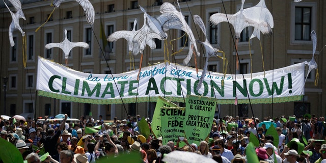 People hold a banner reading ' Climate action Now ' in St. Peter's Square, at the Vatican, Sunday, June 28, 2015. Greeting people Sunday from his studio window, Francis praised a few hundred people who marched to St. Peter's Square under the banner "one Earth, one family." Marchers included Christians, Muslims, Jews, Hindus and others. Their route began near the French embassy to remind people of a climate change conference in Paris later this year. (AP Photo/Andrew Medichini)