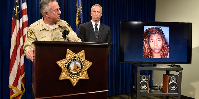 Clark County Sheriff Joe Lombardo, left, and Clark County District Attorney Steve Wolfson attend at a news conference, Monday, Dec. 21, 2015, in Las Vegas. The two officials spoke about the car driven by suspect Lakeisha N. Holloway, pictured on monitor, of Oregon, who police said smashed into crowds of pedestrians on the Las Vegas Strip on Sunday night, killing one person and injuring dozens. (AP Photo/David Becker)