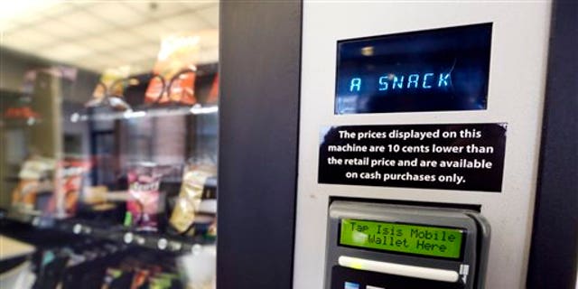 In this Dec. 23, 2013 photo, a vending machine advertises snacks on a small screen on the machine in Seattle. Office workers in search of snacks will be counting calories along with their change under new labeling regulations for vending machines included in President Barack Obama's health care overhaul law. The Food and Drug Administration, which is expected to release final rules early next year, says requiring calorie information to be displayed on roughly 5 million vending machines nationwide will help consumers make healthier choices. (AP Photo/Elaine Thompson)