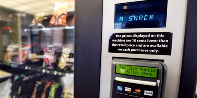 In this Dec. 23, 2013 photo, a vending machine advertises snacks on a small screen on the machine in Seattle. Office workers in search of snacks will be counting calories along with their change under new labeling regulations for vending machines included in President Barack Obama's health care overhaul law. The Food and Drug Administration, which is expected to release final rules early next year, says requiring calorie information to be displayed on roughly 5 million vending machines nationwide will help consumers make healthier choices. (AP Photo/Elaine Thompson)