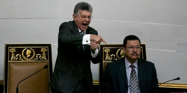 Congressional President Henry Ramos Allup, left center, gives a speech during a special session of Congress in Caracas, Venezuela, Tuesday, Oct. 25, 2016. After the government suspended a recall referendum seeking the president's removal last week, the opposition-controlled congress began debating Venezuelan President Nicolas Maduro's "constitutional situation." Lawmakers vow to present evidence that he's a dual Colombian citizen and therefore constitutionally ineligible to hold Venezuela's highest office. (AP Photo/Alejandro Cegarra)