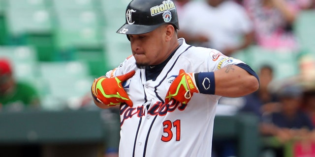 Venezuelas Oswaldo Arcia celebrates at home plate after hitting a home run during a Caribbean Series baseball game against Mexico in San Juan, Puerto Rico, Friday, Feb. 6, 2015. (AP Photo/Ricardo Arduengo)