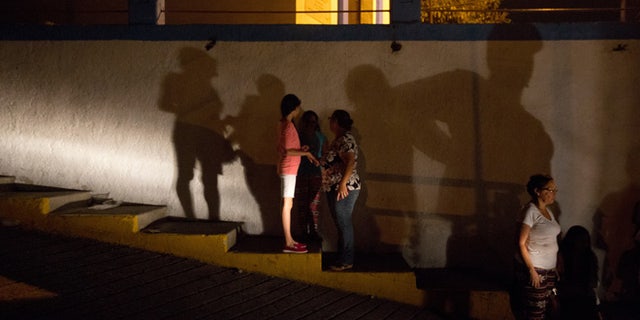 In this Saturday, April 23, 2016 photo, residents make their way to a protest against energy rationing after going through a 24-hour blackout, in the El Calvario neighborhood of El Hatillo, just outside of Caracas, Venezuela. Energy rationing has been added to the hardships faced by Venezuelans overwhelmed by inflation, shortages of food and medicine and rising crime. (AP Photo/Fernando Llano)
