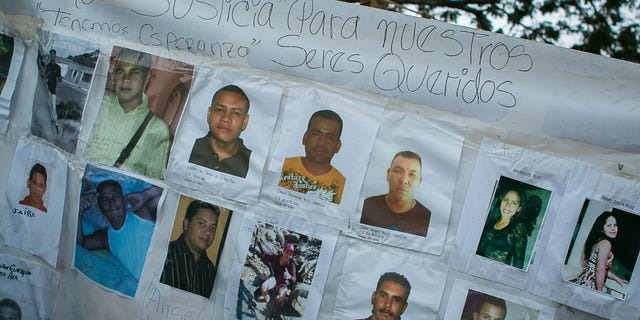 A banner with photos of several missing miners hangs on a tree near Tumeremo, Venezuela, Tuesday, March 8, 2016.