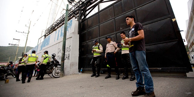A group of Bolivarian Police officers stand at the gate of distribution center belonging to Venezuelas largest food company, Empresas Polar, in La Yaguara in Caracas, Venezuela, Thursday, July 30, 2015. According to Empresas Polar director Manuel Felipe Larrazabal the government occupied of one of its Caracas food distribution centers. President Nicolas Maduro has accused Polar of sabotaging the economy by hoarding goods and intentionally creating shortages, a charge the company has denied. (AP Photo/Ariana Cubillos)