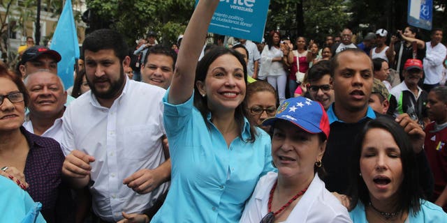 Monday, Aug. 3, 2015: Opposition leader Maria Corina Machado waves as she and her supporters arrive to the National Electoral Council (CNE) with the intention of registering her candidacy for congressional elections in Los Teques, Venezuela.
