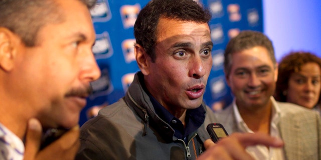 Opposition leader Henrique Capriles, center, speaks to the press. (AP Photo/Ariana Cubillos)