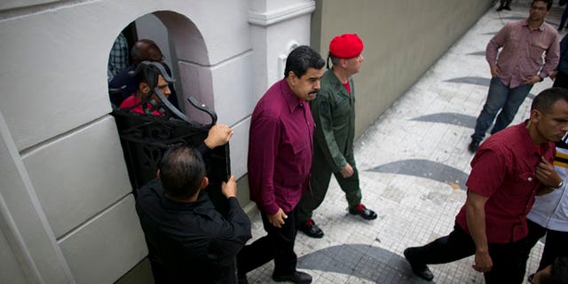 President Maduro exits an area of Miraflores presidential palace in Caracas, Venezuela, Friday, Oct. 28, 2016.
