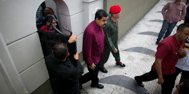 President Maduro exits an area of Miraflores presidential palace in Caracas, Venezuela, Friday, Oct. 28, 2016.