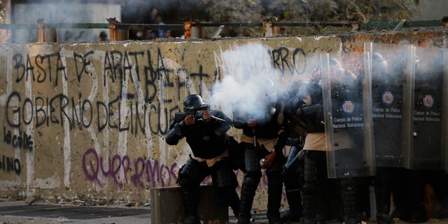 Police officers fire teargas at demonstrators during clashes in Caracas, Venezuela, Wednesday, March 5, 2014.