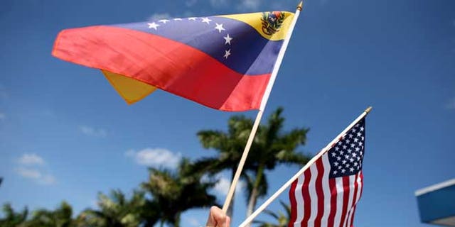 MIAMI, FL - MARCH 01:  A protester holds a Venezuelan and American flag as she and other Venezuelans and their supporters show their support for the anti-government protests in Venezuela on March 1, 2014 in Miami, Florida.  (Photo by Joe Raedle/Getty Images)